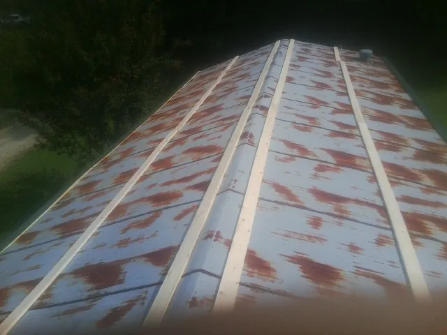 Rusted metal roof panels with new wood purlins before replacement — Storm Damage Roof Repair in Gill by Roofing Brothers