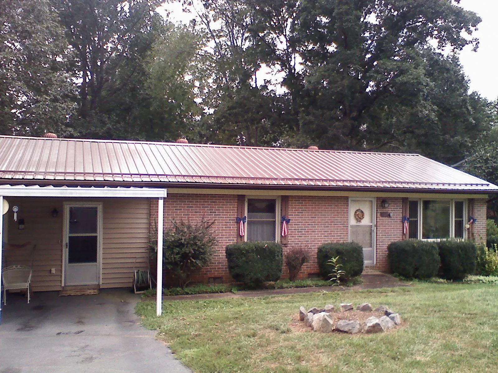 Bronze metal roof and carport on a brick ranch home in Gill